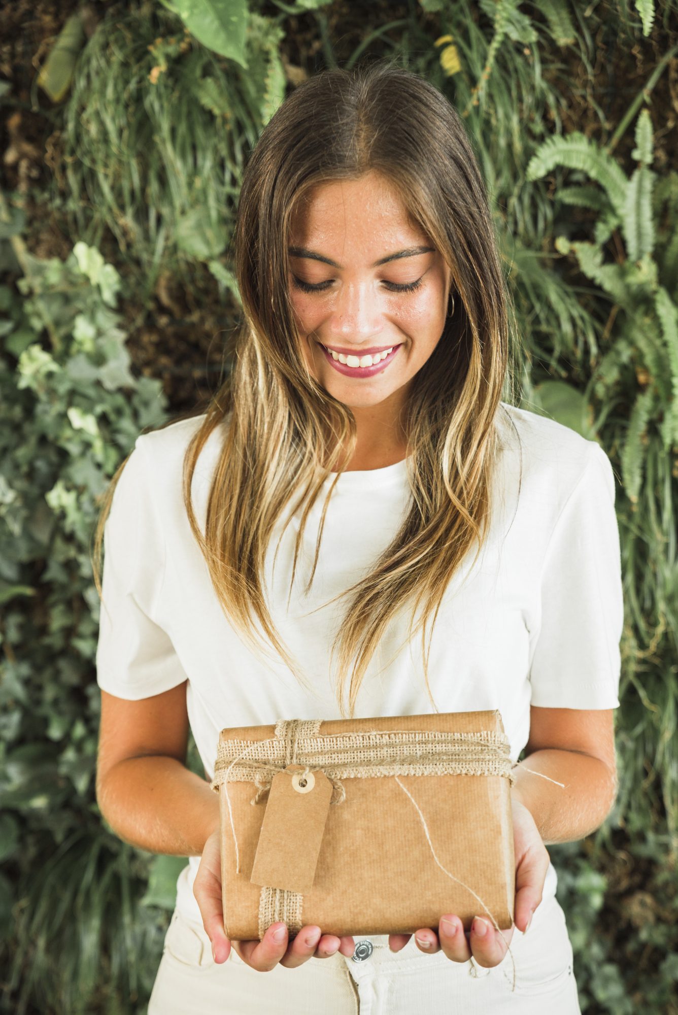 Mujer sonriente sosteniendo una caja de regalo